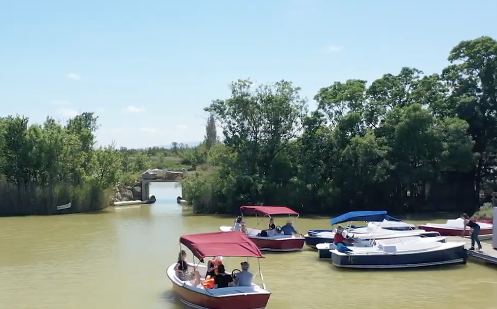 Famille à bord d'un bateau électrique naviguant sur les canaux du Domaine Sainte Marthe au cœur des marais de Narbonne.