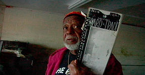 A Black man holds up an historical document ruined by Hurricane Katrina in Brent Joseph's film "A Loud Color"