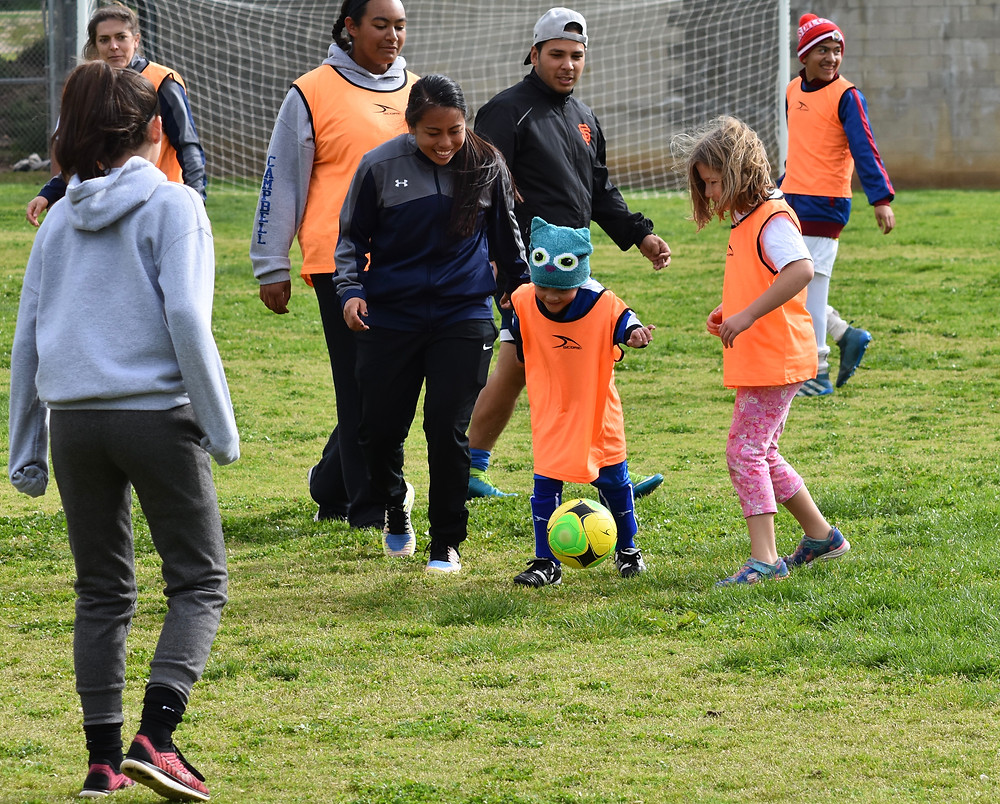 TOPSoccer’s youngest member Amaya is encouraged to dribble downfield by SeaLion midfielder Elissa Magracia.