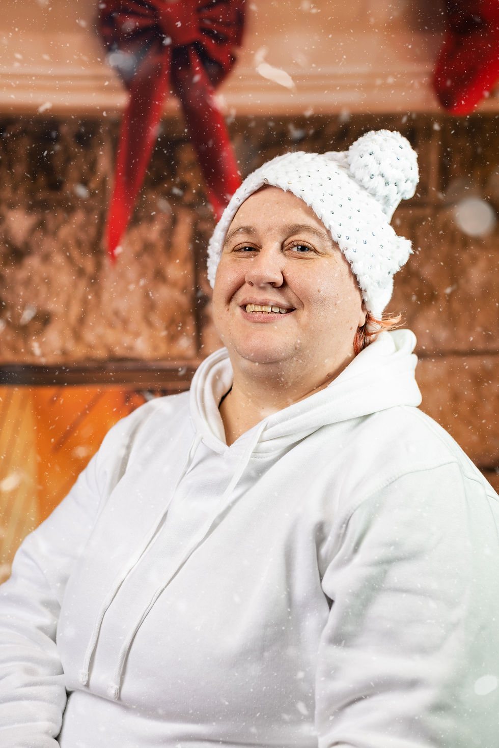 Emma Williams, in a white Santa hat, in front of our background.