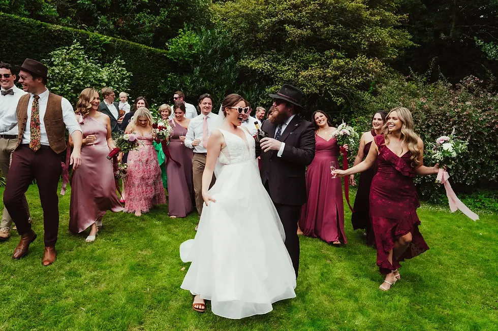 Meg Senior | FAQs for wedding celebrants | Newlywed couple celebrating with champagne, surrounded by their best friends