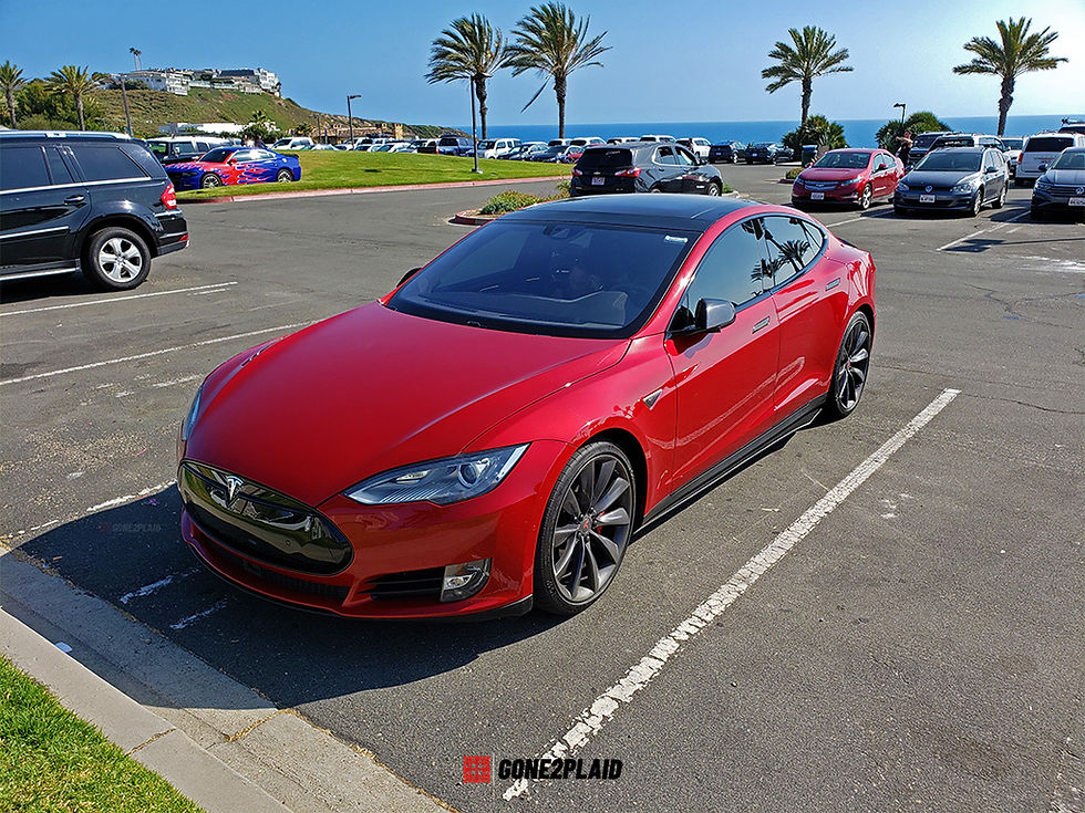 Tesla Model S chrome blackout / chrome delete kit from Nikola Pro for a custom red 2016 Tesla Model S P90D / P90DL with Ludicrous Mode. Final pictures of the car in Dana Point California after all chrome delete items have been installed. Front driver side profile.
