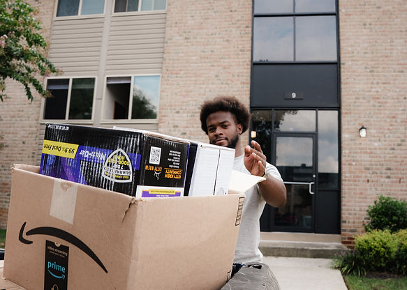 "Clear Cut Cleanouts worker loading a box of household items into a junk removal truck during a cleanout service."
