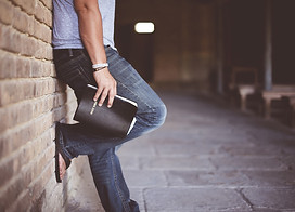 Bible-Man-standing-against-wall