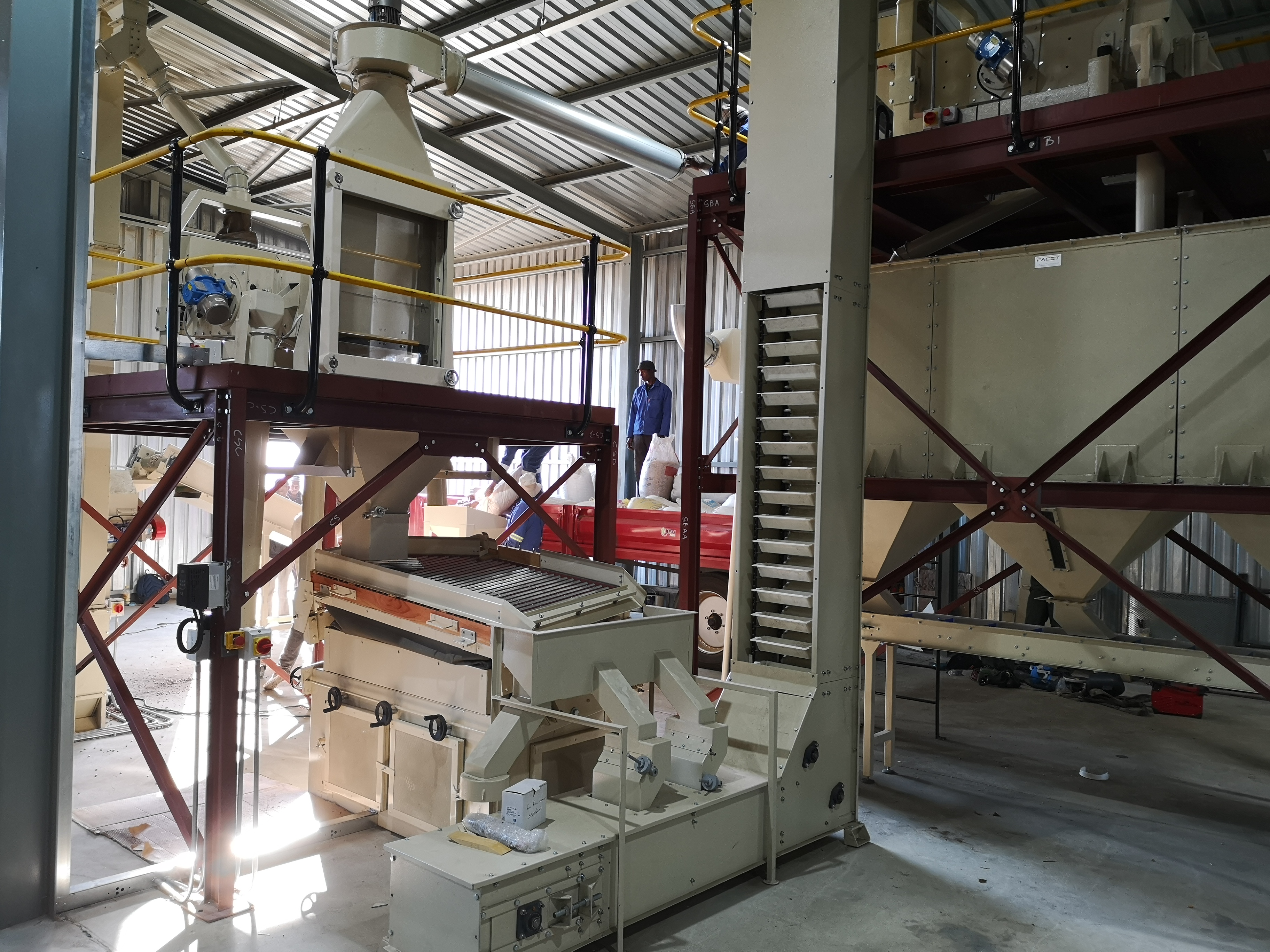 Gravity tables, bucket elevator, and colour sorter in bean plant