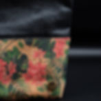 Kosmetikbeutel aus Kork mit tropischem, rosafarbenen Hibiskusblüten und grünen Blättern. Obere Hälfte aus schwarzem Kunstlede