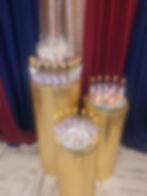 3 gold round columns with party desserts on top