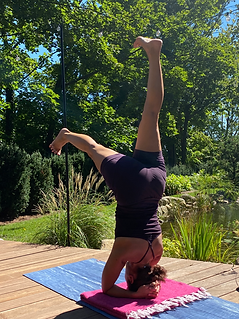 Sophie practicing headstand on the studio deck