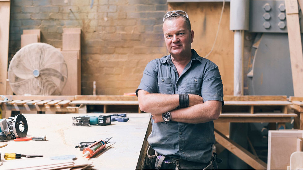 man with arms crossed in workshop