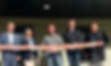 Multiple community leaders cutting a ribbon at an event