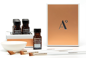 Bottles of AlumierMD Radiant 30 Chemical Peel in a box with a bowl and brushes used for the treatment at Secret Faces Medical Aesthetics Boutique in Oakville.