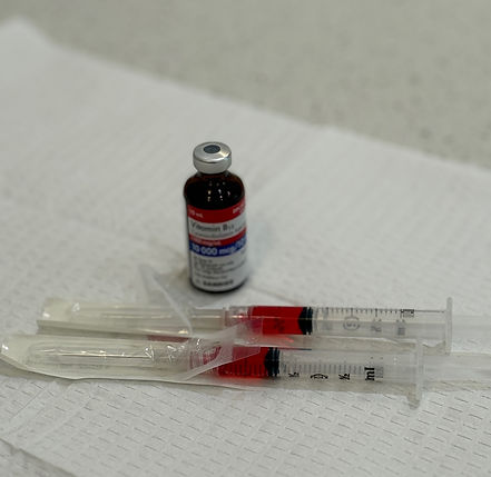 Bottle of Vitamin B12 and two sterile syringes on paper towel prepped for a client at Prestige Medical Aesthetics Georgina.