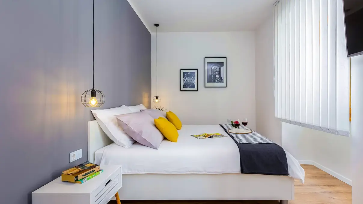 Bedroom with comfortable bed and decorative lighting in Terra I apartment, Rijeka