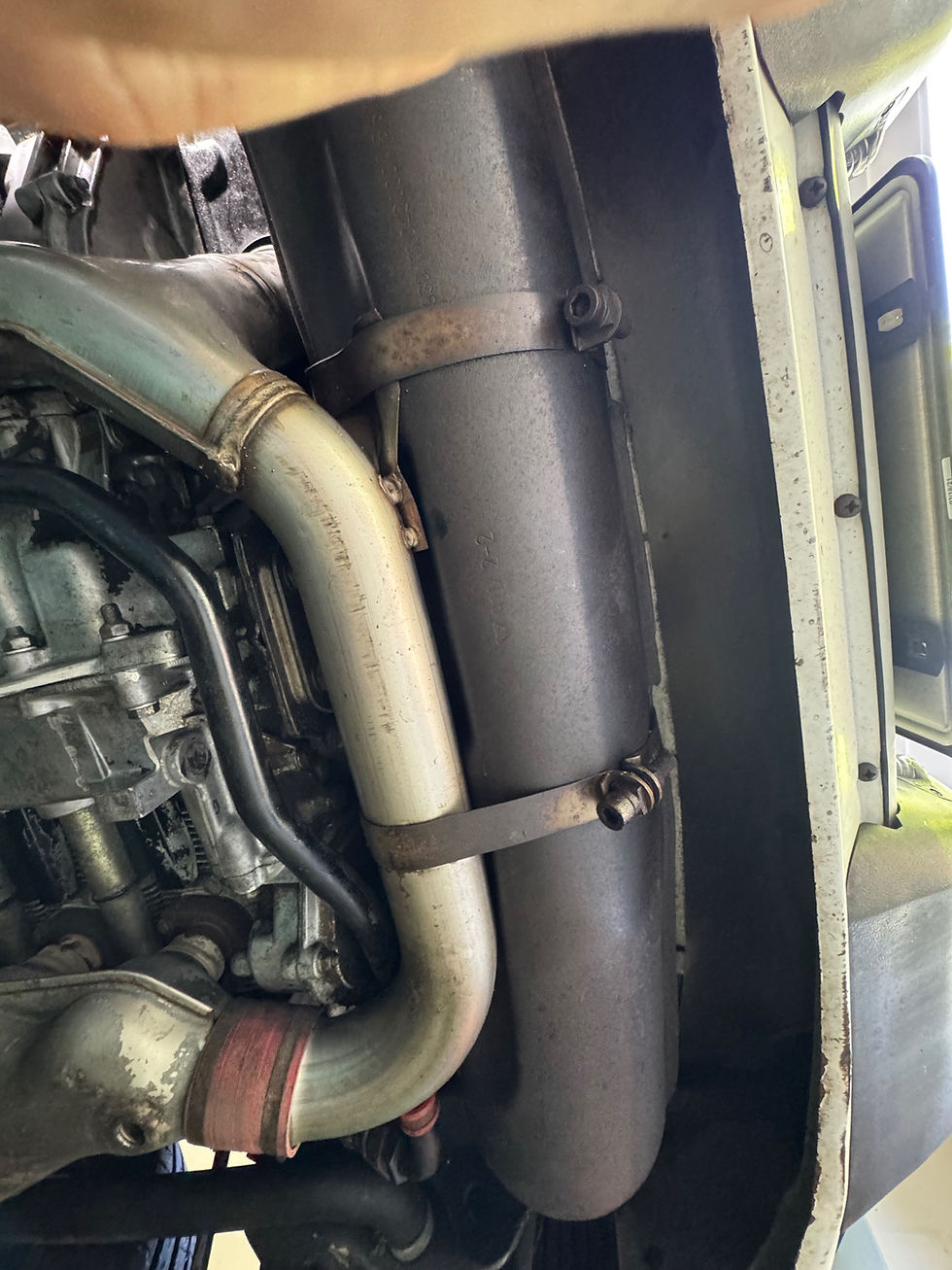 The stock muffler is held in by these 2 straps and the 3 bolts that connect to the pre-muffler or cat. There are cutaways on the muffler body to help locate the straps and it can’t fall on your head - you have to slide it in (or out) from the left side, and then the hot air pipe and bumper keep it from falling. Very thoughtful. 