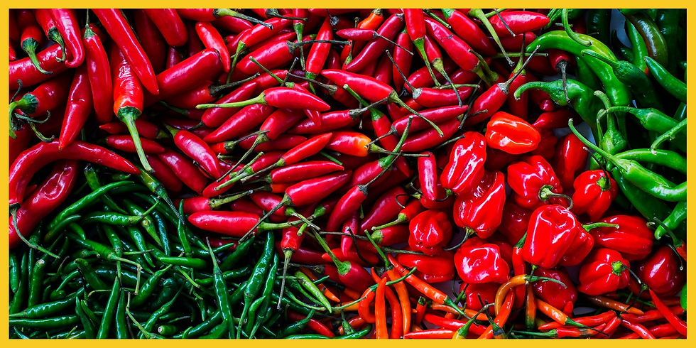 A colorful assortment of red and green peppers stacked together in a large pile.