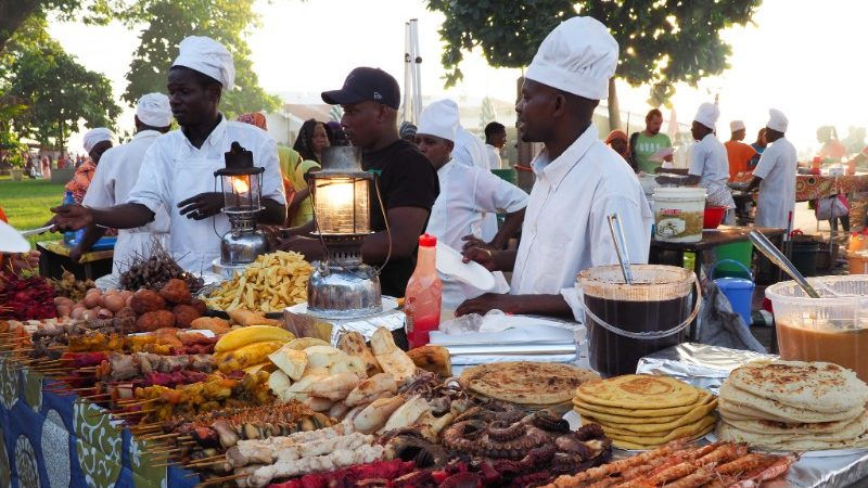 A group of chefs cooking at a food stand, preparing delicious meals for customers.