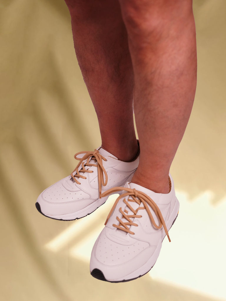 ミルクティーカラーのジャケットをもったワンピース姿の女性