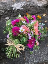 Tied bunch of garden seasonal flowers, bright pink, pale pink, yellow & white flowers with greenery
