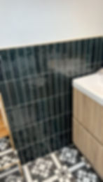 Modern bathroom renovations in London with black tiles.