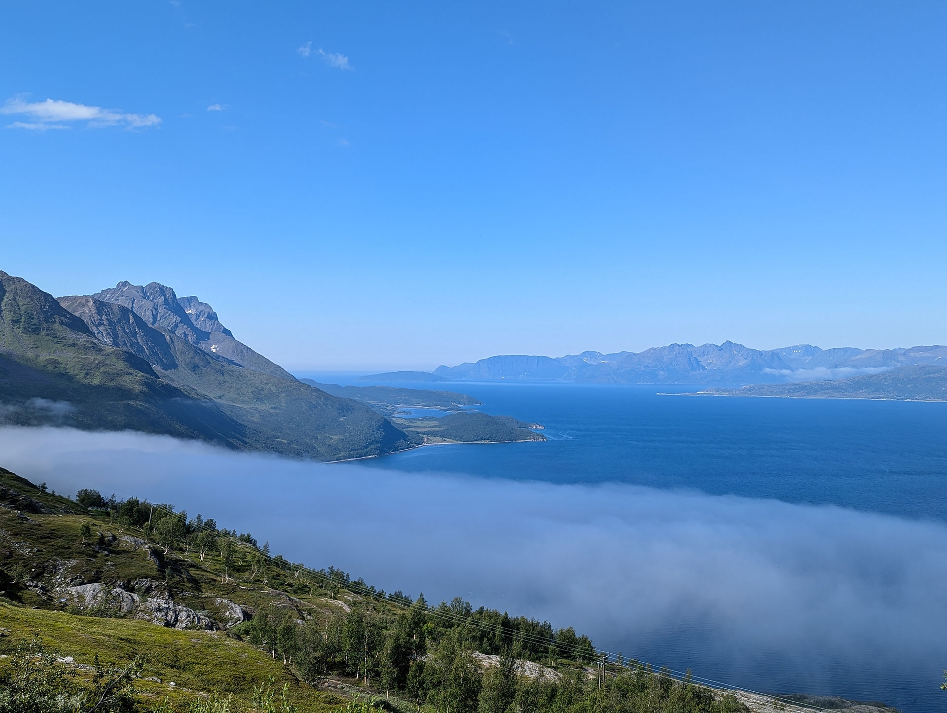 Utsikt over tåken, mot fjell i horisonten