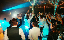 Invités dansant sous des guirlandes lumineuses au Domaine de l’Oiselière pendant la soirée.