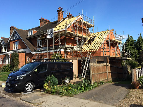 Home with scaffolding with Tony Adams Builds van on driveway