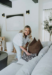Designer fluffing pillows on modern couch