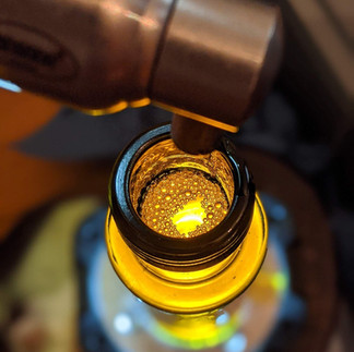 der Blick von oben in eine gefüllte Ölflasche unter dem Ausguss der Ölkanne