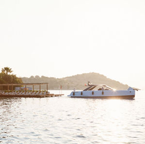 A yacht preparing to depart the pontoon at the Maçakizi Bodrum beach club.
