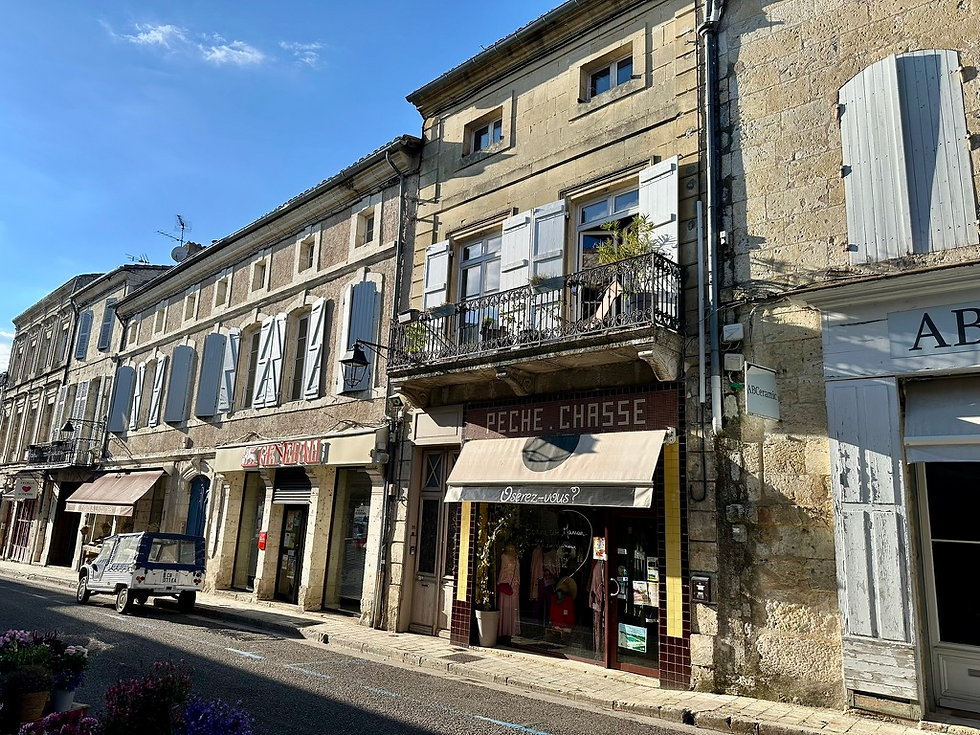 Café and shops on a village street along the Via Podiensis GR65 in France
