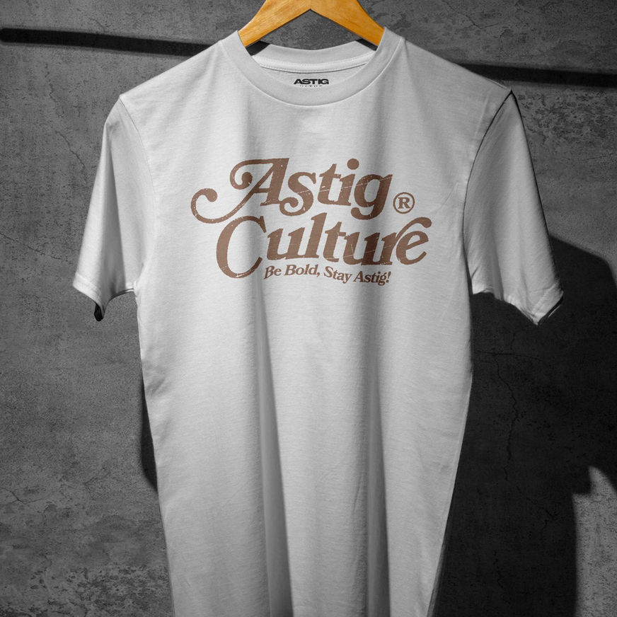 White T-shirt with bold brown text "Astig Culture" in a stylized font. Below, smaller text reads "Be Bold, Stay Astig!"