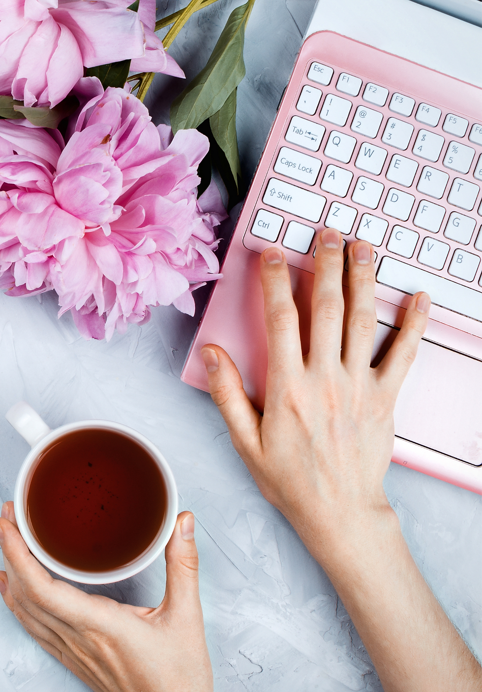 Woman typing with pink flowers. 