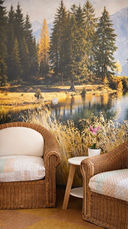 Korbsessel vor einem Wandbild mit Bergsee und Wald.