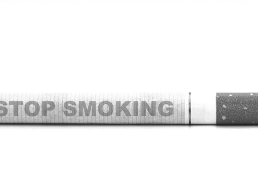 Close-up of a cigarette labeled ‘Stop Smoking,’ representing tobacco harm reduction policy and the transition away from combustible products.