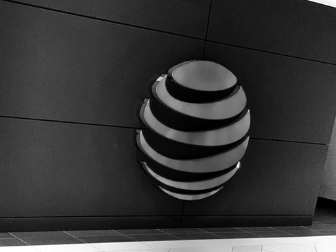 Illuminated AT&T logo on a dark wall, showcasing the company's modern branding.