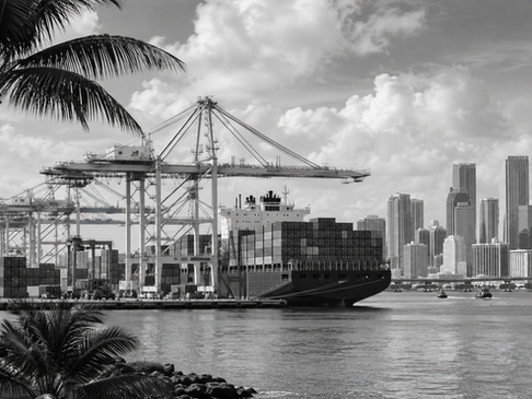 Black and white view of a Florida container port with cargo ship, cranes, and the Miami skyline representing the state’s maritime economy