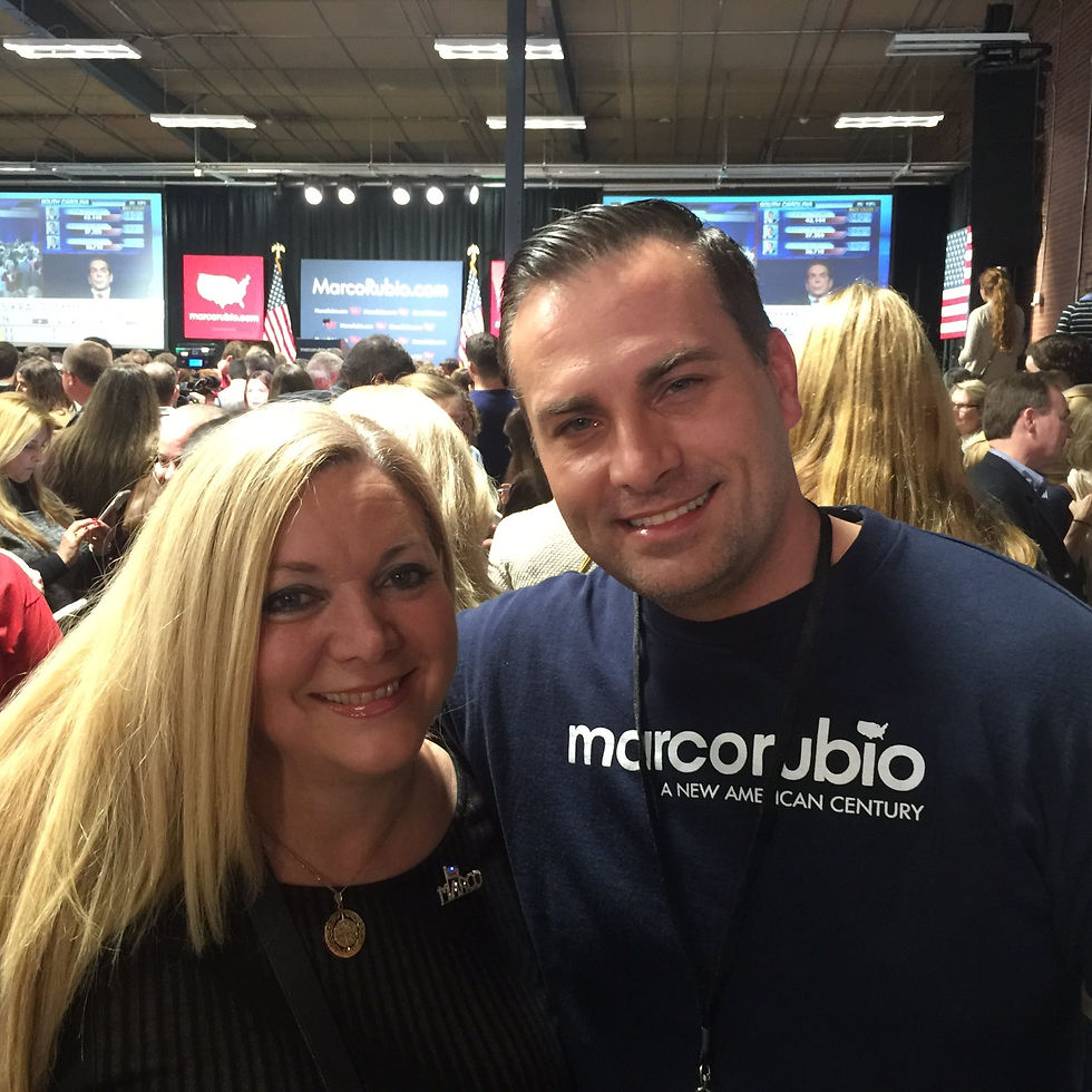 Sebastian Aleksander and Alina Garcia at a 2016 Marco Rubio presidential campaign rally in South Carolina, standing together in a crowded event hall with the stage and campaign signage in the background.