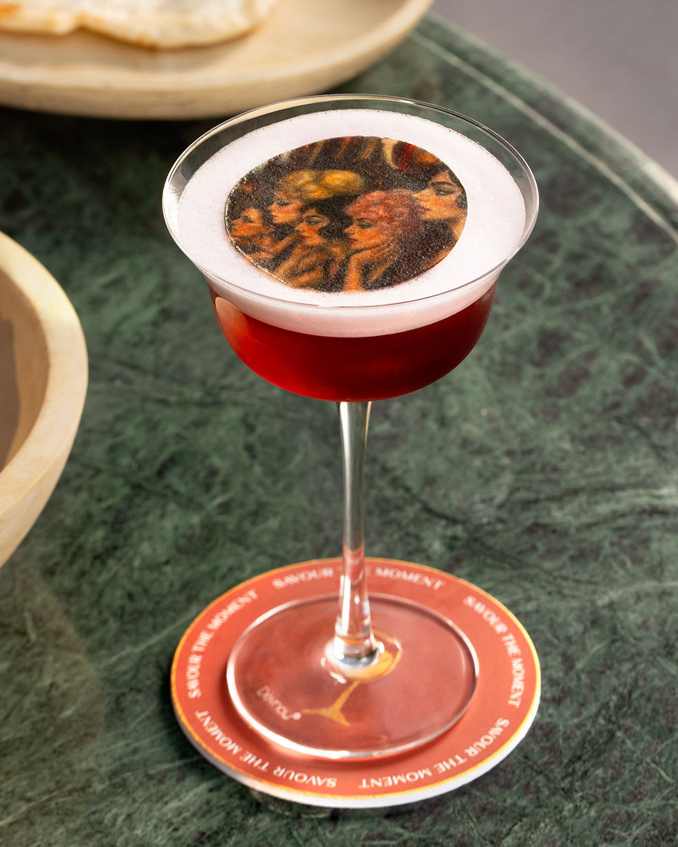Signature red cocktail with artistic foam served at Vicoli, a European social dining restaurant in Gurugram