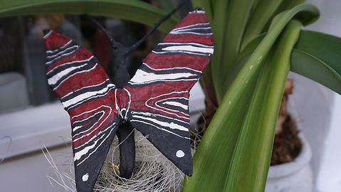 Schmetterling aus Draht und Papier, rot bemalt mit schwarzen und weißen Streifen