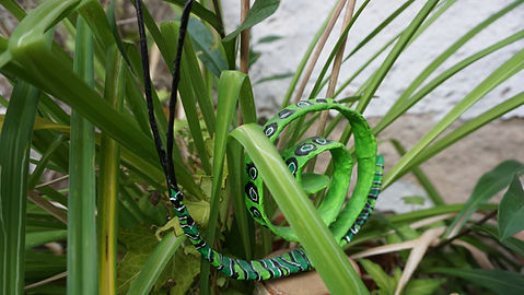 Schnecke aus Draht und Papier, grün bemalt mit Linien und Kreisen in Schwarz und Weiß