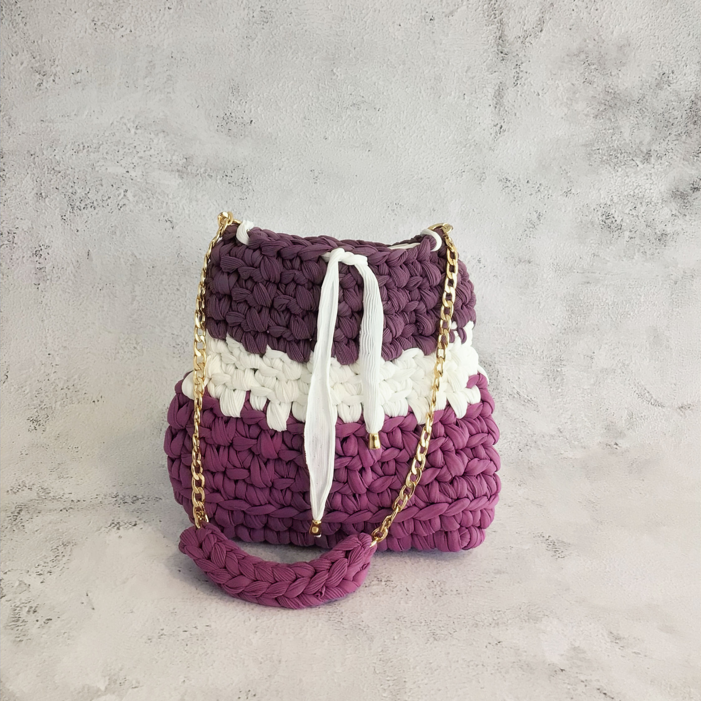 Crochet Bucket Bag in Purple and White color-block with a white drawstring closure and Golden Chain strap.