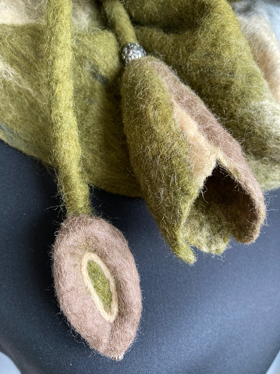 Vue de près sur un lien en laine feutrée pour resserrer le tour de cou. Accessoire mode femme.