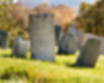 Old weathered headstones in a cemetery during spring