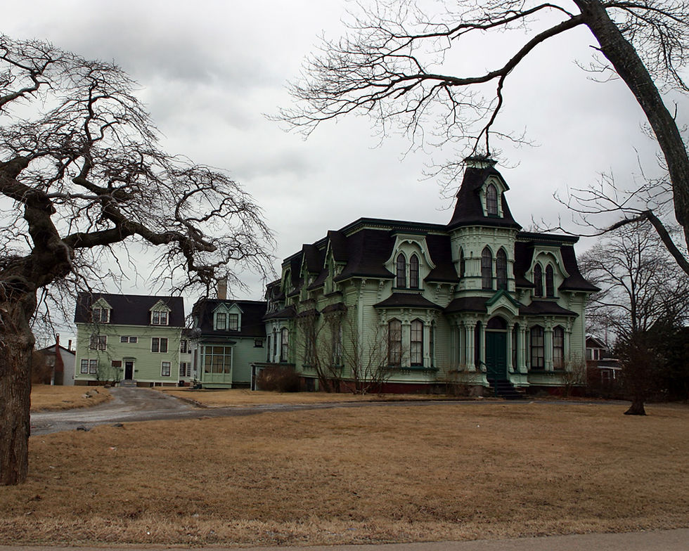 Photo of a spooky looking mansion with a dead tree
