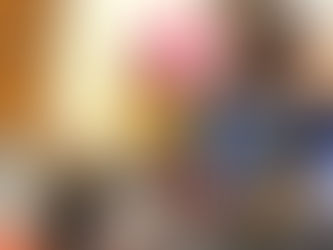 A woman shows a book reading "Swish" to a child in a classroom. The child sits on a colorful mat, looking up attentively.