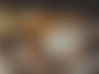 Cozy kitten sleeping on a knit blanket beside an open book, with a floral teacup in the background, creating a warm, relaxed atmosphere.