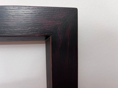 Close-up of picture frame corner to show detail of milk paint finish and wood grain.