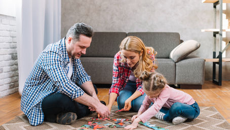 Rodzice układający puzzle edukacyjne z dziećmi