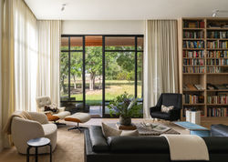 Mid-century modern custom home interior living space with library sitting area and views of the Drif