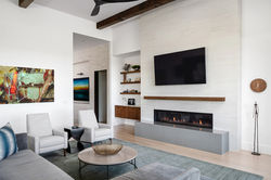 Contemporary living room featuring clean lines, warm materials, modern fireplace.